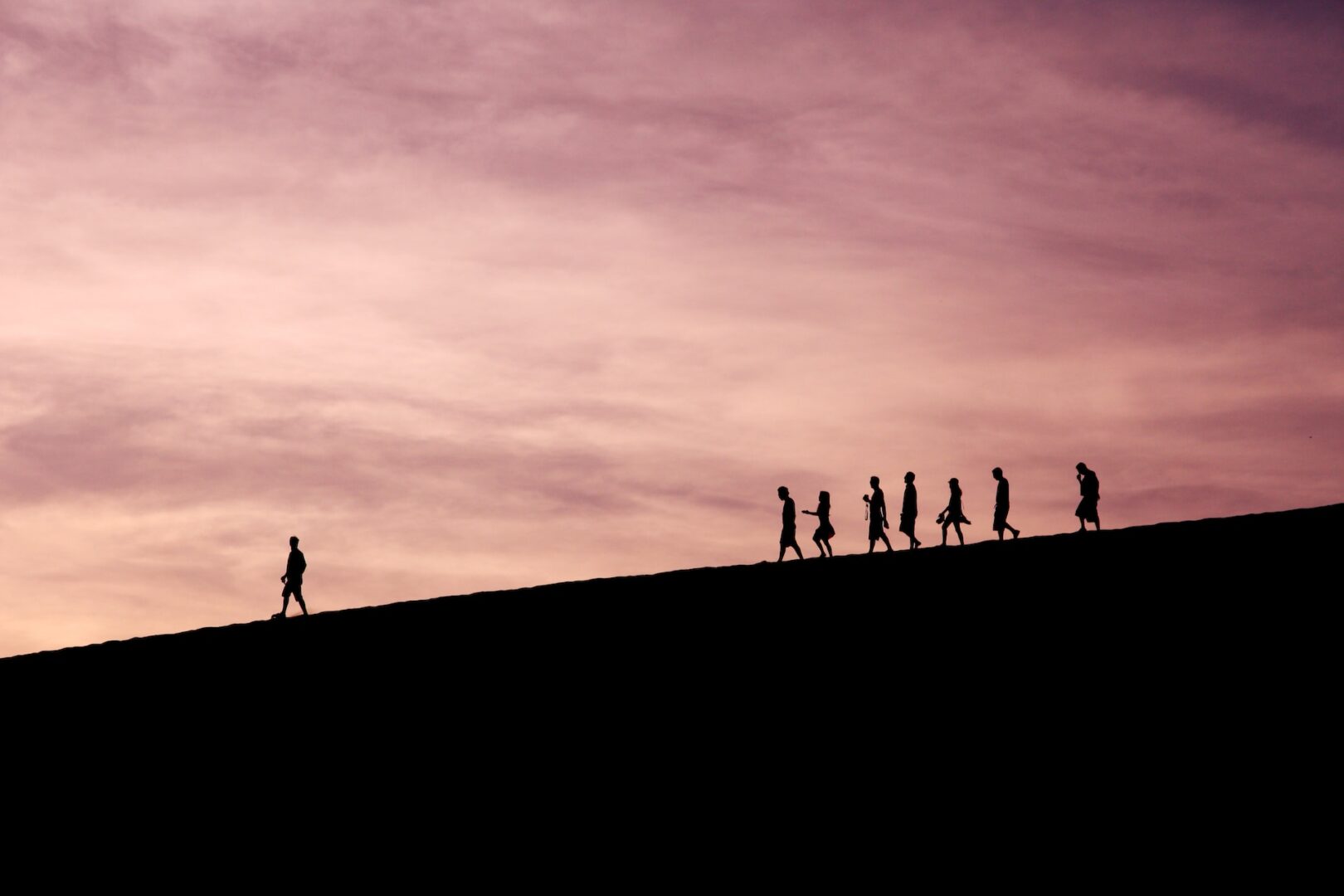A group of people walking up the side of a hill.